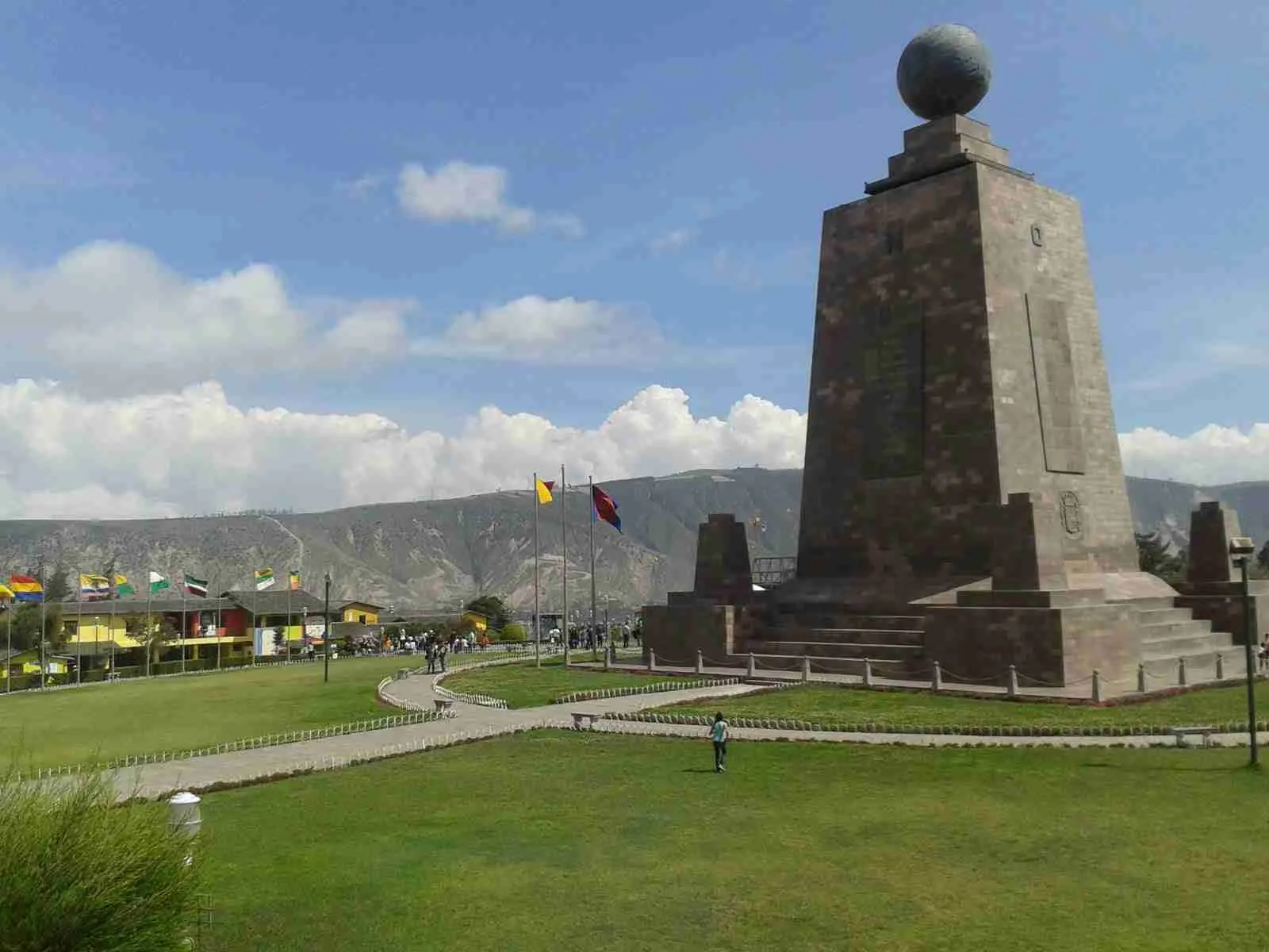 Monumento de la Mitad del Mundo con su esfera, banderas y jardines