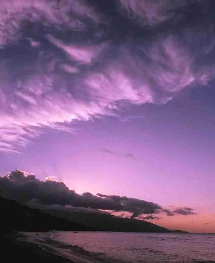 Cielo violeta al atardecer sobre la costa y las montañas