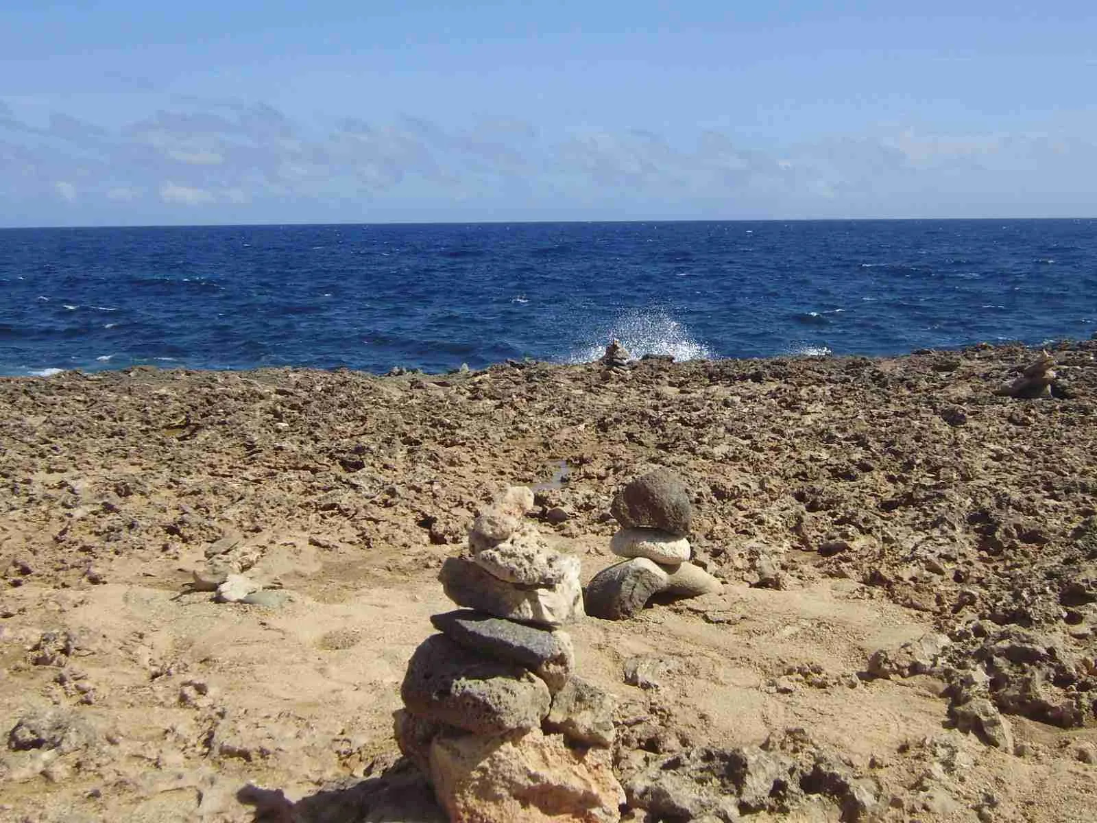 Costa rocosa con pequeñas torres de piedras apiladas frente al mar