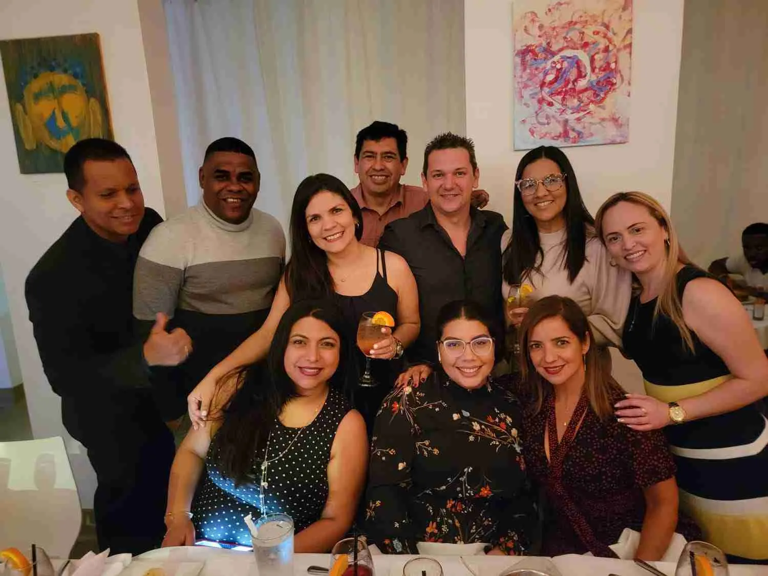Grupo de compañeros posando abrazados en un restaurante